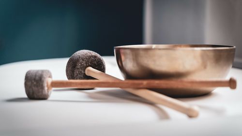 Singing bowl with two sticks on a table.